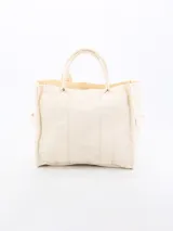 Bolso tipo tote bag de lona en color crudo, con diseño estructurado, doble asa de mano y costuras reforzadas.