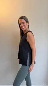 Musculosa deportiva negra de corte holgado, con cuello redondo y aberturas laterales que brindan mayor libertad de movimiento.