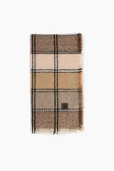 Pashmina de tejido suave con diseño de cuadros en tonos marrones, beige y negro. Presenta terminaciones con flecos en los bordes y una pequeña etiqueta decorativa.