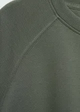 Buzo de cuello redondo y manga larga con diseño recto y costuras decorativas. Confeccionado en tejido fluido de textura tipo piqué.