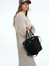 Kimono largo de tejido de punto en color beige, con diseño de sisa caída y mangas abullonadas que aportan volumen. Presenta una silueta relajada y abierta al frente.