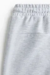 Pantalón de jogging gris melange, de corte recto y calce regular. Presenta cintura elástica con cordón ajustable y bolsillos laterales insertados.