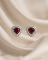 Aros tipo caravana de plata con diseño triangular y piedra central de circonia en forma de corazón color granate, rodeada por pequeñas circonias blancas.