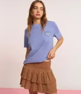Remera celeste de corte amplio, con cuello redondo y mangas cortas. Estampado en la espalda con un corazón y texto en color azul.