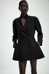 Blazer negro de corte entallado con cuello solapa, manga larga y cierre frontal cruzado con dos botones.