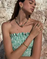 Brazalete rígido abierto de bronce con textura irregular.