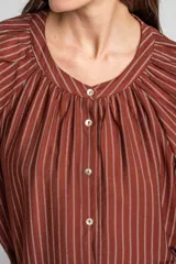Blusa de manga larga con diseño a rayas verticales, cuello redondo con pequeña abertura frontal abotonada y mangas con puños elásticos.