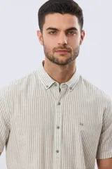 Camisa de manga corta confeccionada en mezcla de lino y algodón, con diseño de rayas verticales en tonos celeste y blanco. Cuenta con cuello camisero, botonadura frontal y bordado sutil en el pecho.