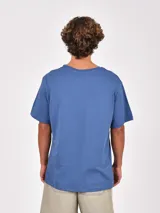 Remera blanca de manga corta con cuello redondo y un bolsillo simple en el pecho.