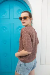 Saco tejido calado color ocre, con mangas al codo y botones de coco. Tiene grifa de cuero en la espalda.