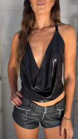 Top negro brillante con escote drapeado y espalda descubierta.