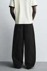 Jeans de denim de algodón color negro, con corte balloon fit relajado desde la cadera y ligeramente estrechado en el bajo. Tiro medio, cinco bolsillos y cierre frontal con cremallera y botón.