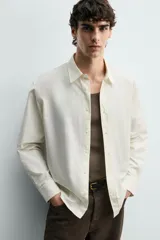 Camisa regular fit de color celeste, confeccionada en tejido con mezcla de algodón y seda, con cuello solapa, manga larga con puño abotonado y cierre frontal de botonadura.