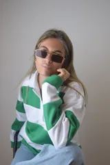 Sweater blanco con rayas horizontales verdes, de corte holgado y mangas largas.