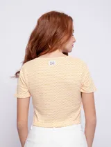 Top de manga corta con escote en V y fruncido ajustable con lazo en el centro, de tela texturizada con estampado de puntos pequeños.