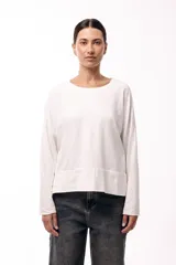 Remera de silueta amplia con hombro caído y cuello redondo, confeccionada en tejido suave de algodón. Presenta un diseño holgado y versátil con mangas largas.