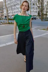 Pantalón tipo culotte de tiro alto confeccionado en denim azul oscuro. Presenta pinzas delanteras, pernera ancha y corta, bolsillos laterales ocultos y cierre frontal con cremallera, botón y ganchos.