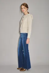 Jean de corte acampanado con tiro alto, confeccionado en denim azul con lavado medio y costuras a tono.