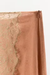 Falda midi de tiro medio confeccionada en viscosa, con diseño asimétrico y aplicación de encaje a contraste en el bajo y lateral. Cuenta con cierre lateral mediante cremallera oculta.
