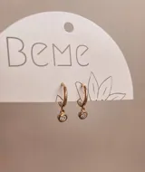 Aros dorados tipo argolla con dije colgante de cristal.