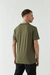 Remera polo negra de manga corta con ajuste regular. Presenta cuello y puños con ribete a rayas en gris y bordó. El logo de la marca está estampado en el pecho.