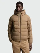 Campera puffer Moncler modelo Zeflor de color tostado, con diseño acolchado horizontal, capucha integrada con cordones anchos ajustables y cierre frontal de cremallera doble.