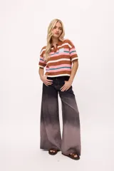 Remera de tejido de punto con cuello polo, diseño de rayas horizontales en tonos marrón, rosa, blanco y verde azulado, corte boxy y mangas cortas.