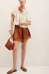 Short de satén color marrón, con diseño fluido, tiro medio y detalles de encaje a tono en el ruedo.
