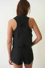 Short negro de tiro bajo, confeccionado en denim 100% algodón con proceso de encuerado. Tiene cuatro bolsillos, pasa cintos, cremallera y botón metálico.