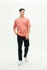 Remera de manga corta color salmón, con cuello redondo y corte regular. Presenta un estampado circular en relieve en el pecho con la frase 'It's gonna be a good day' y el logo de la marca Brooksfield.