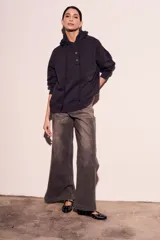 Sweater con capucha color negro, con cordones ajustables y botones en el escote.