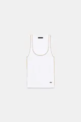 Musculosa de algodón color blanco con cuello redondo amplio y sisas. Cuenta con detalles de ribetes dorados brillantes en el escote, tirantes y costuras laterales.