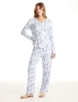 Conjunto de pijama compuesto por una remera de manga larga con escote en V, abertura frontal con botones y bolsillo aplicado, y un pantalón con cintura elástica y lazo de ajuste. Presenta un estampado animal print en tonos neutros.