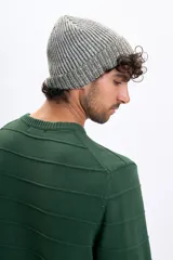 Buzo de punto color verde con diseño de rayas horizontales en relieve, cuello redondo y puños acanalados.