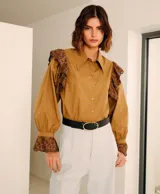 Camisa color marrón con cuello clásico, mangas largas abullonadas con puños elásticos y detalles de encaje floral en hombros y puños.