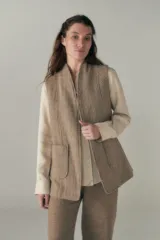 Chaleco color crema con solapas, corte entallado y bolsillos plaqué.