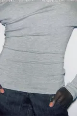 Top de tejido suave con diseño asimétrico, escote descubierto en un hombro y manga larga.