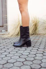 Botas de cuero negro con caña media, taco cuadrado y puntera redondeada.