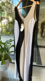 Collar con dije de nácar de forma irregular y orgánica, suspendido de un cordón fino en tono neutro.