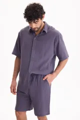 Bermuda negra de muselina con corte baggy, estilo deportivo y cordón ajustable en la cintura.