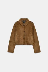 Chaqueta corta de efecto ante en color marrón, con cuello solapa, manga larga y trabillas en los hombros. Presenta cierre frontal con botones y bolsillos delanteros de doble vivo.