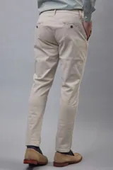 Pantalón de gabardina color azul marino, de corte ajustado y tiro medio, con cierre y botón frontal.