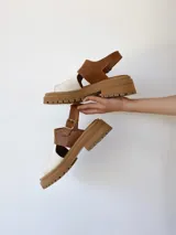 Sandalias de cuero color camel y crudo, con plataforma track y hebilla ajustable.