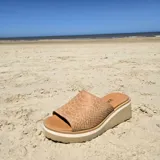 Zuecos de cuero color tostado con textura de reptil, plataforma baja y suela cómoda.