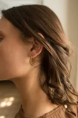 Aros tipo argolla dorados con diseño de bolitas.