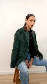 Blazer verde pino de gamuza con cuello marrón chocolate, botones de cuerno, forro interior y bolsillos con solapa.