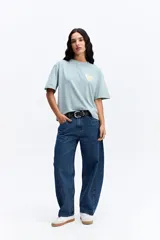 Remera de corte oversize color verde agua con efecto acid wash, cuello redondo y estampa pequeña en el pecho. Presenta una silueta relajada y mangas cortas.
