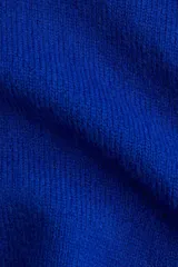 Buzo de tejido punto fino suave, color azul eléctrico, con cuello tipo polo abierto en V y hombros caídos. Presenta remates acanalados en puños y bajo.