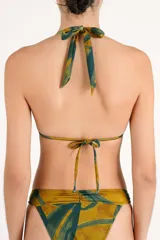 Top de bikini triangular con estampado abstracto en tonos verde y mostaza, con tirantes anudados al cuello y a la espalda, y argollas metálicas doradas en las uniones de los breteles.