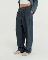 Pantalón de lino con efecto gastado, de tiro medio y silueta relajada con piernas curvas. Presenta pinzas frontales, bolsillos laterales, bolsillo ojal en la pierna izquierda y en la parte trasera. Largo al tobillo.